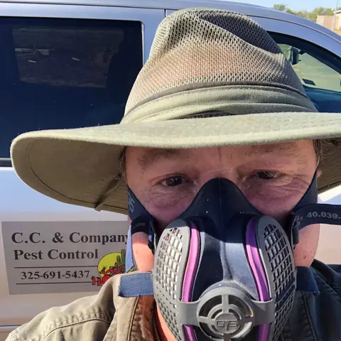 Keith Weaver of C.C. & Co. Pest Control wearing a respirator in front of his service truck in Abilene, Texas